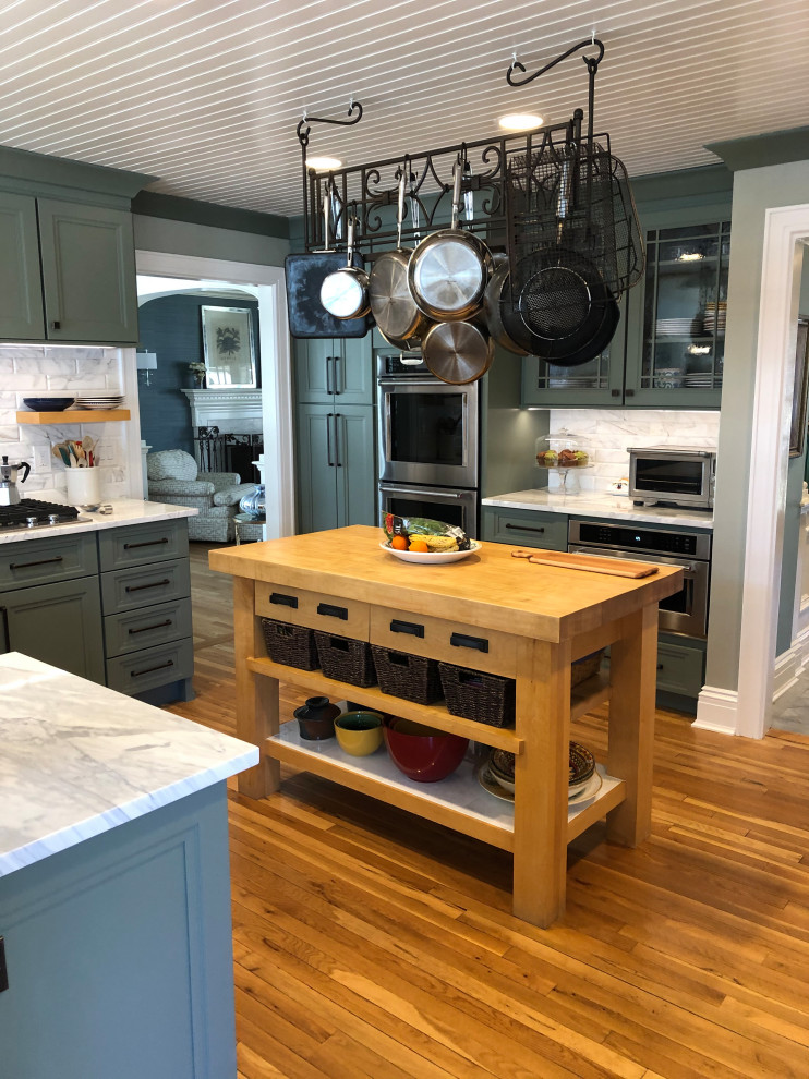 Eat-in kitchen - large country u-shaped medium tone wood floor, brown floor and shiplap ceiling eat-in kitchen idea in Other with a farmhouse sink, recessed-panel cabinets, green cabinets, marble countertops, white backsplash, marble backsplash, stainless steel appliances, a peninsula and multicolored countertops