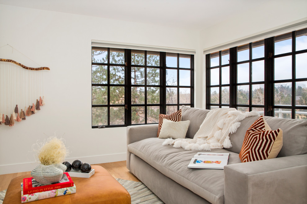 Mittelgroßes, Fernseherloses Modernes Wohnzimmer im Loft-Stil mit weißer Wandfarbe, braunem Holzboden, Kamin und Kaminumrandung aus Metall in Denver