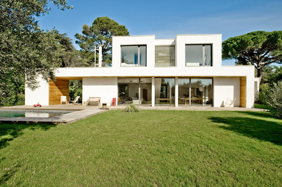 This is an example of a large modern two-storey white exterior in Montpellier with a flat roof.