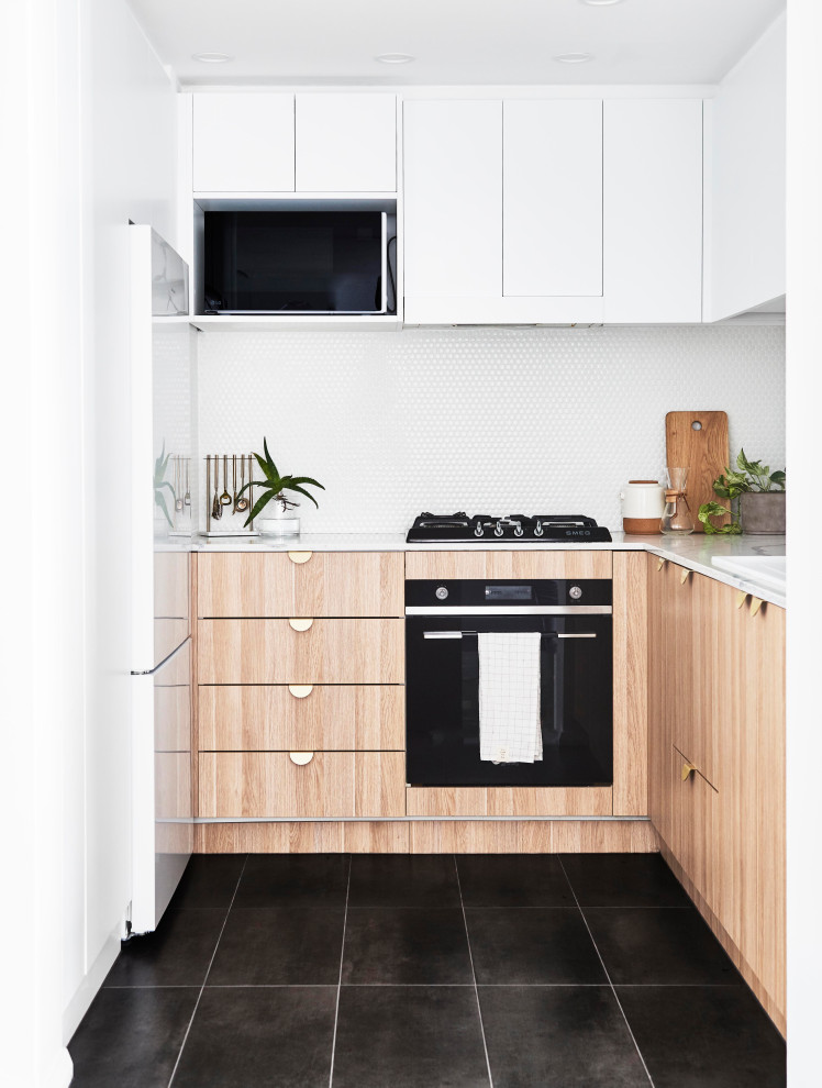 Inspiration for a small contemporary u-shaped separate kitchen in Sydney with a drop-in sink, light wood cabinets, white splashback, mosaic tile splashback, black appliances, cement tiles, no island, grey floor, white benchtop and flat-panel cabinets.
