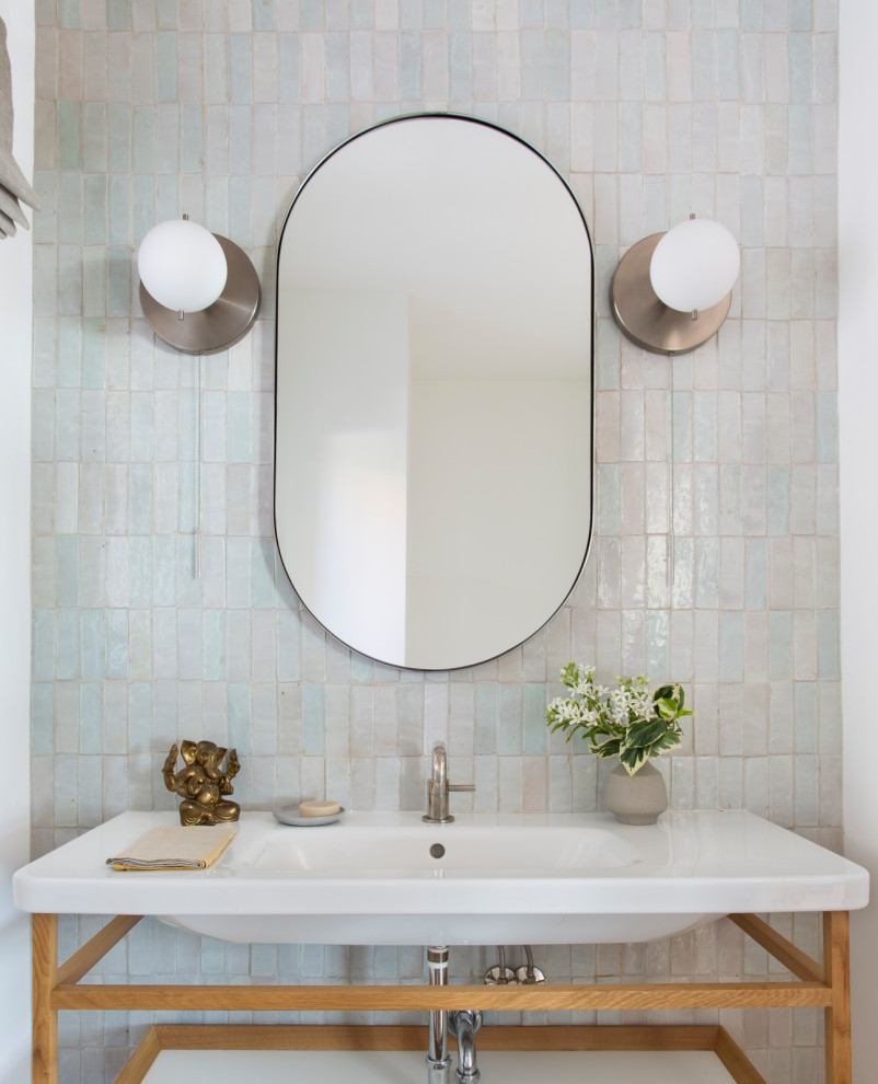 Immagine di una stanza da bagno design con nessun'anta, ante in legno chiaro, piastrelle multicolore, pareti bianche, lavabo a consolle, top bianco, un lavabo e mobile bagno freestanding