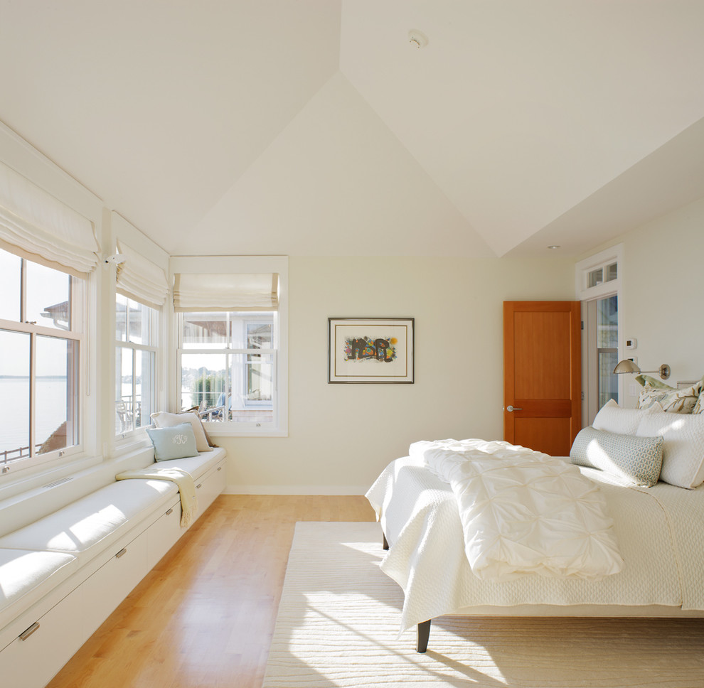 Inspiration for a traditional master bedroom in Providence with beige walls and light hardwood floors.