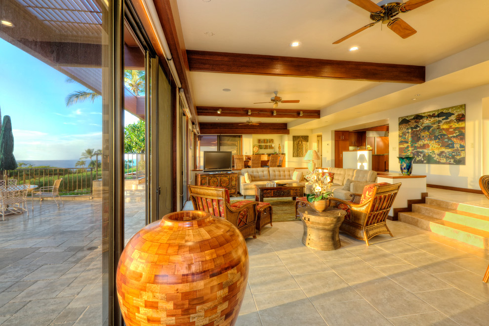 This is an example of a mid-sized beach style open concept living room in Hawaii with white walls, ceramic floors, no fireplace, a freestanding tv and beige floor.