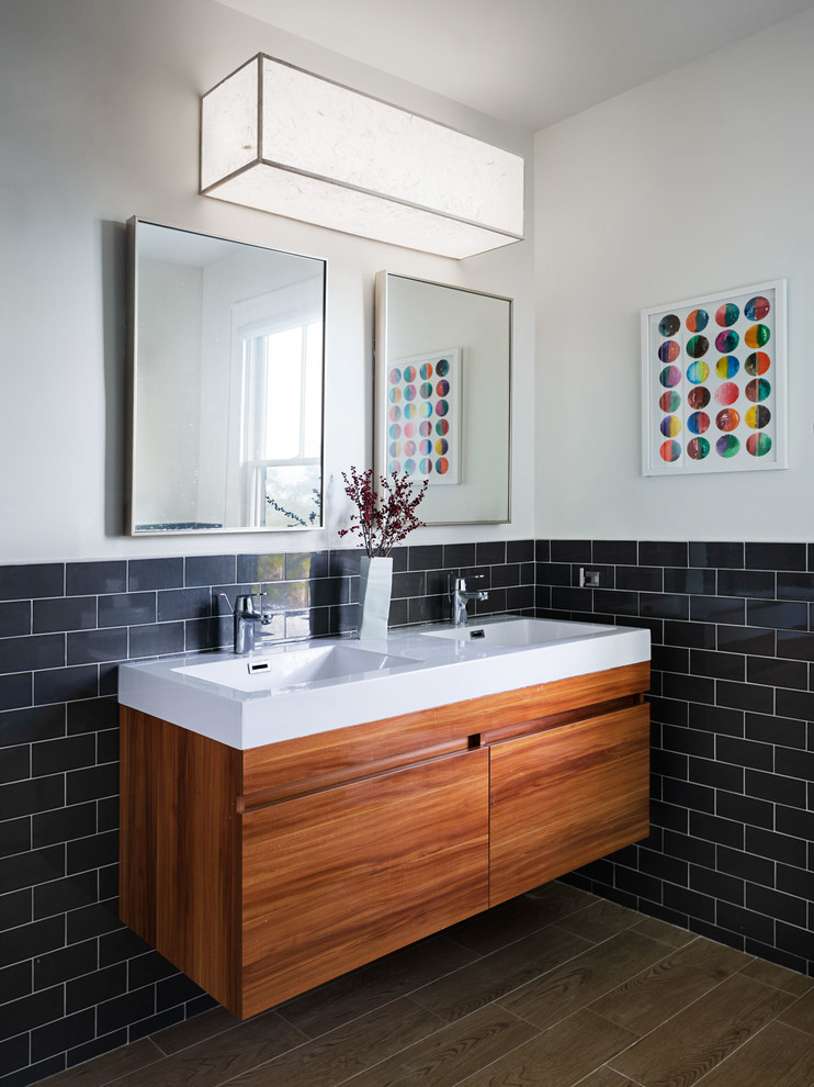 Design ideas for a mid-sized contemporary kids bathroom in New York with flat-panel cabinets, medium wood cabinets, subway tile, white walls, an integrated sink, brown floor, white benchtops, engineered quartz benchtops and gray tile.