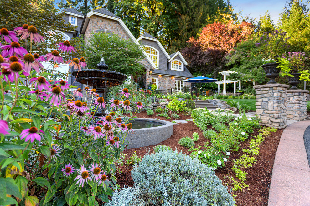 Foto di un grande giardino xeriscape classico esposto in pieno sole davanti casa con pavimentazioni in cemento e recinzione in metallo