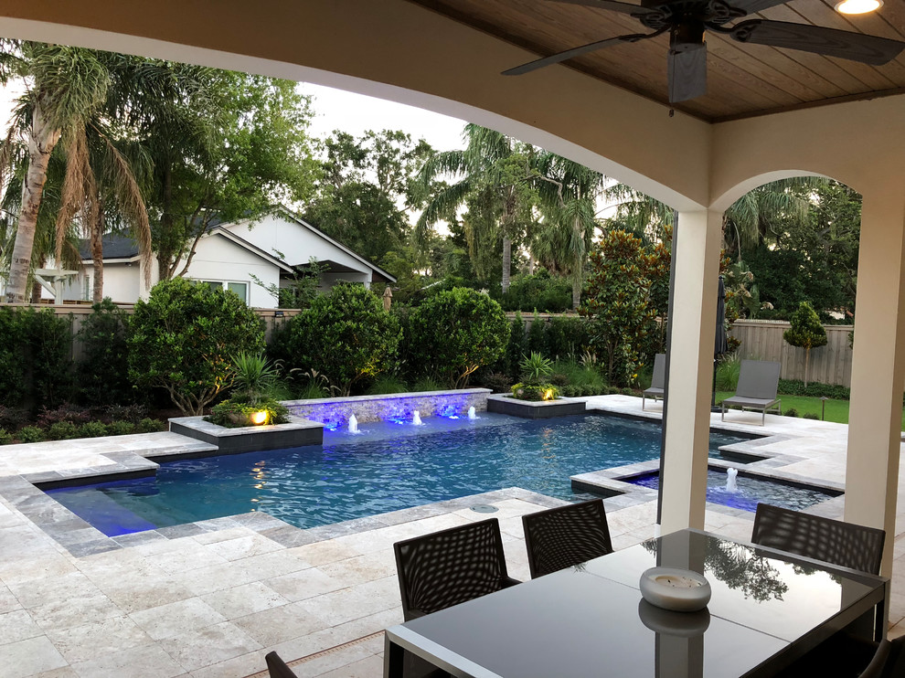 Design ideas for a large contemporary backyard patio in Orlando with a water feature, natural stone pavers and no cover.