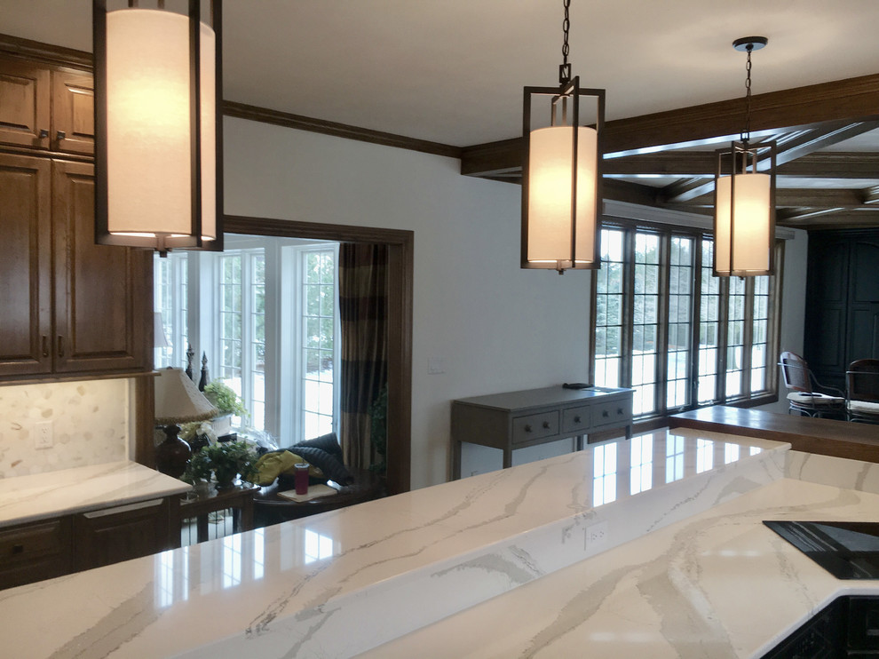 Example of a large transitional u-shaped medium tone wood floor open concept kitchen design with an undermount sink, recessed-panel cabinets, distressed cabinets, quartz countertops, multicolored backsplash, mosaic tile backsplash, stainless steel appliances and an island