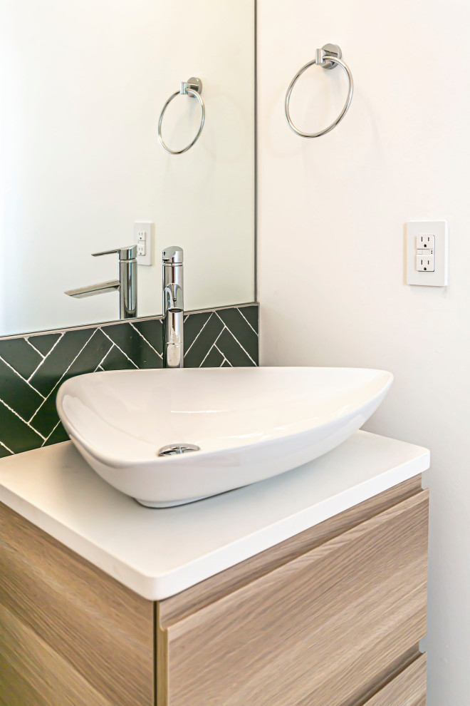 Immagine di un piccolo bagno di servizio design con ante lisce, ante in legno chiaro, piastrelle nere, top in marmo e mobile bagno sospeso