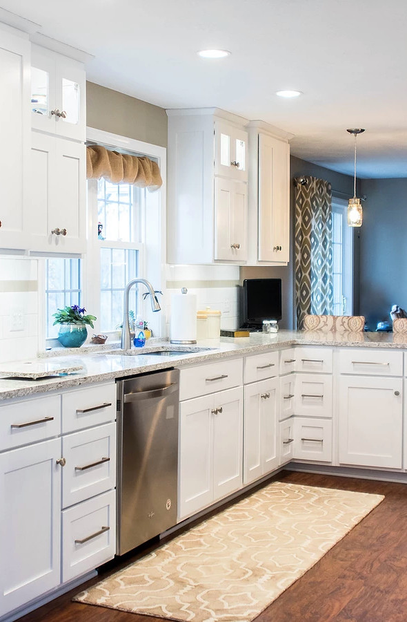 Example of a large transitional galley medium tone wood floor and brown floor enclosed kitchen design with an undermount sink, white cabinets, quartzite countertops, white backsplash, stainless steel appliances, shaker cabinets, ceramic backsplash, a peninsula and multicolored countertops