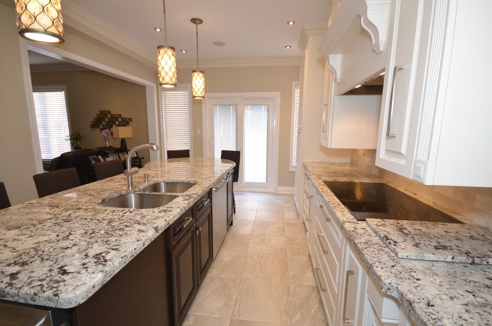 Mid-sized transitional l-shaped porcelain tile enclosed kitchen photo in Toronto with an undermount sink, raised-panel cabinets, white cabinets, granite countertops, beige backsplash, stainless steel appliances and an island