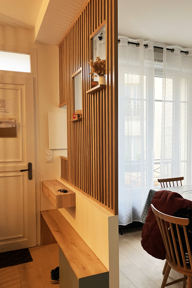 Entryway - small contemporary medium tone wood floor, beige floor and wainscoting entryway idea in Le Havre with beige walls and a white front door