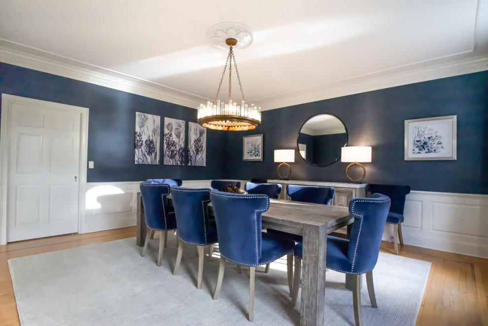 Idee per una sala da pranzo chic chiusa e di medie dimensioni con pareti blu, pavimento in legno massello medio e carta da parati
