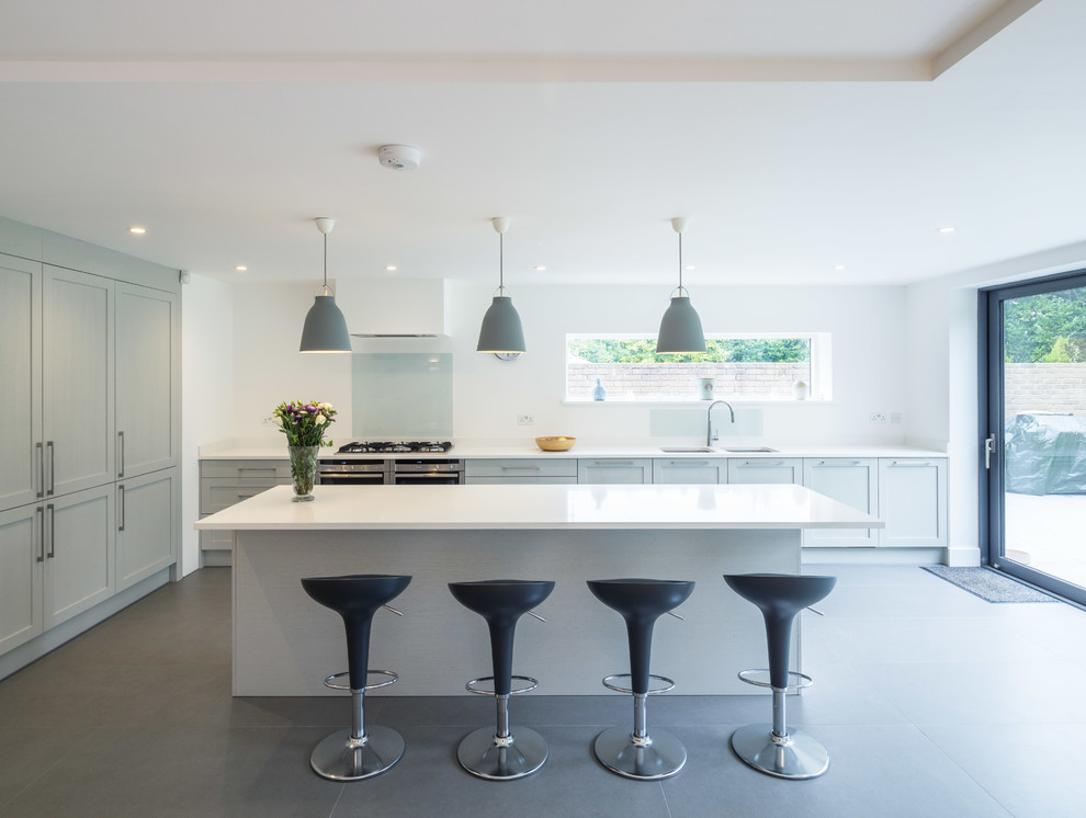 Inspiration for a large contemporary kitchen in London with an undermount sink, shaker cabinets, grey cabinets, white splashback, glass sheet splashback, panelled appliances and with island.