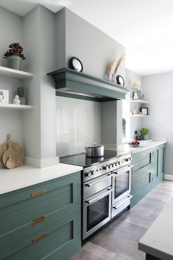 Esempio di un cucina con isola centrale minimal chiuso e di medie dimensioni con lavello sottopiano, ante in stile shaker, ante verdi, top in quarzite, paraspruzzi bianco, paraspruzzi in quarzo composito, elettrodomestici in acciaio inossidabile, pavimento in vinile, pavimento marrone e top bianco
