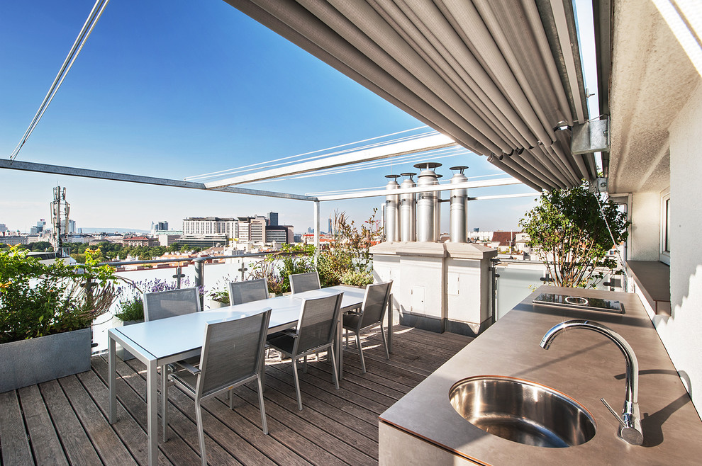 This is an example of a contemporary rooftop and rooftop deck in Other with an outdoor kitchen and an awning.