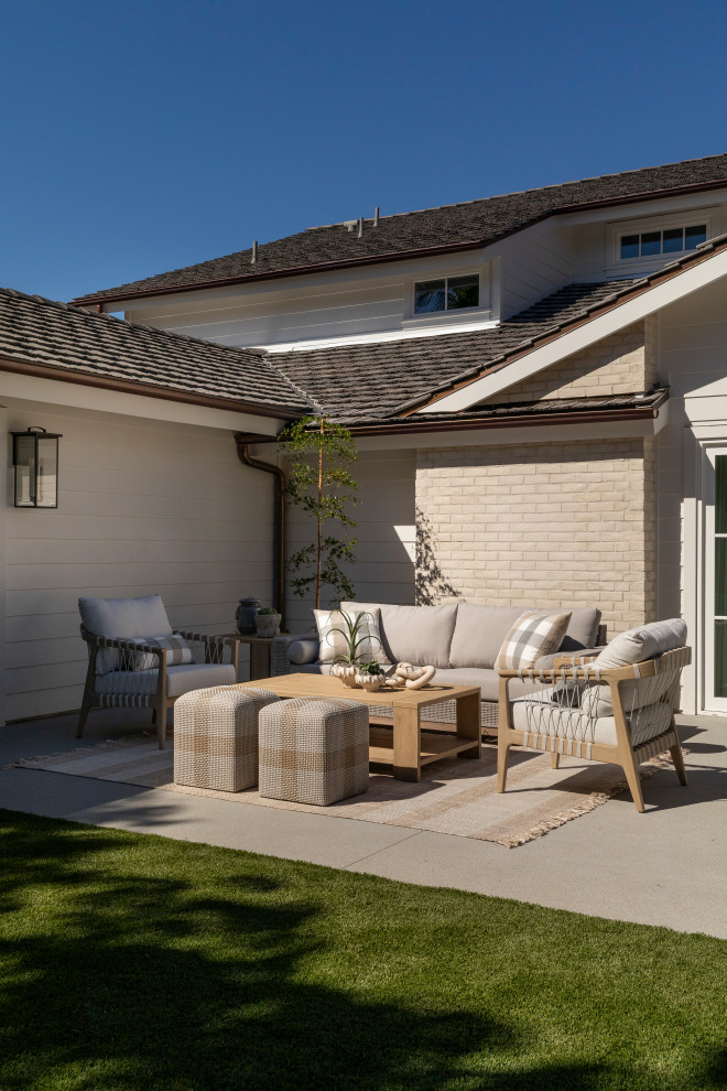 Coastal white two-story mixed siding and clapboard house exterior idea in Orange County with a tile roof and a brown roof