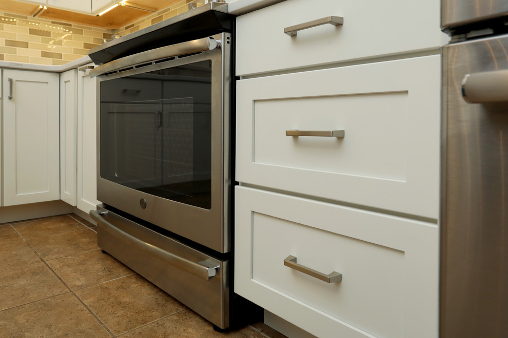 Small transitional ceramic tile and beige floor kitchen photo with a double-bowl sink, shaker cabinets, quartz countertops, beige backsplash, ceramic backsplash, stainless steel appliances and white countertops