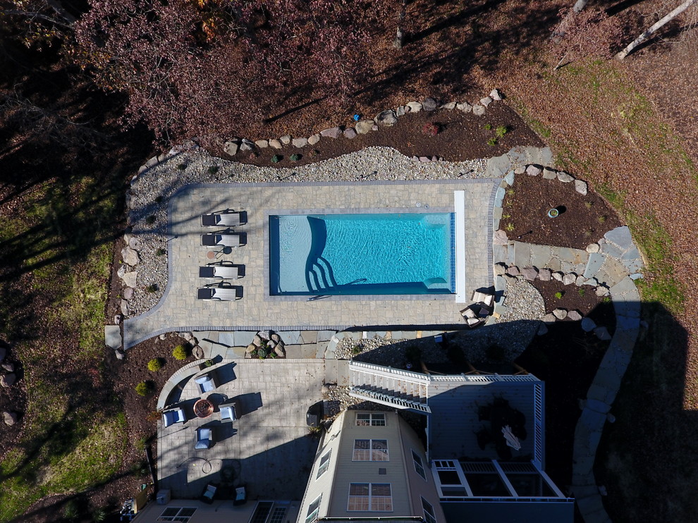 Inspiration for a large rustic backyard concrete paver and rectangular pool remodel in DC Metro