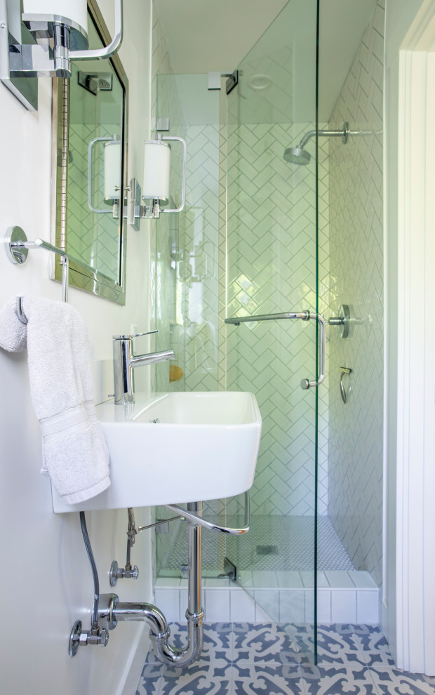 Bild på ett litet lantligt badrum med dusch, med öppna hyllor, vita skåp, en dusch i en alkov, en toalettstol med hel cisternkåpa, vit kakel, porslinskakel, vita väggar, cementgolv, ett väggmonterat handfat, blått golv och dusch med gångjärnsdörr