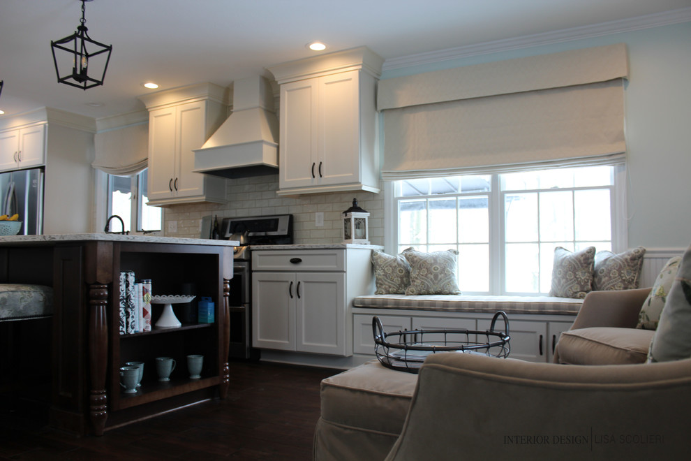 Example of a large mountain style single-wall dark wood floor and brown floor eat-in kitchen design with a farmhouse sink, shaker cabinets, white cabinets, quartz countertops, white backsplash, ceramic backsplash, stainless steel appliances and an island