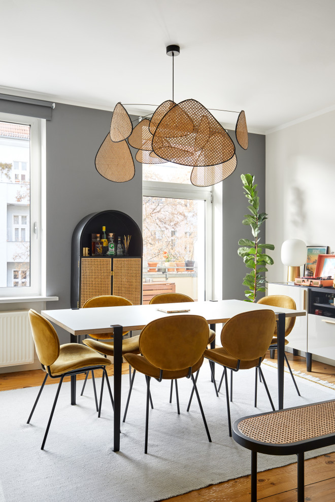 Modernes Esszimmer mit grauer Wandfarbe, braunem Holzboden und braunem Boden in Berlin