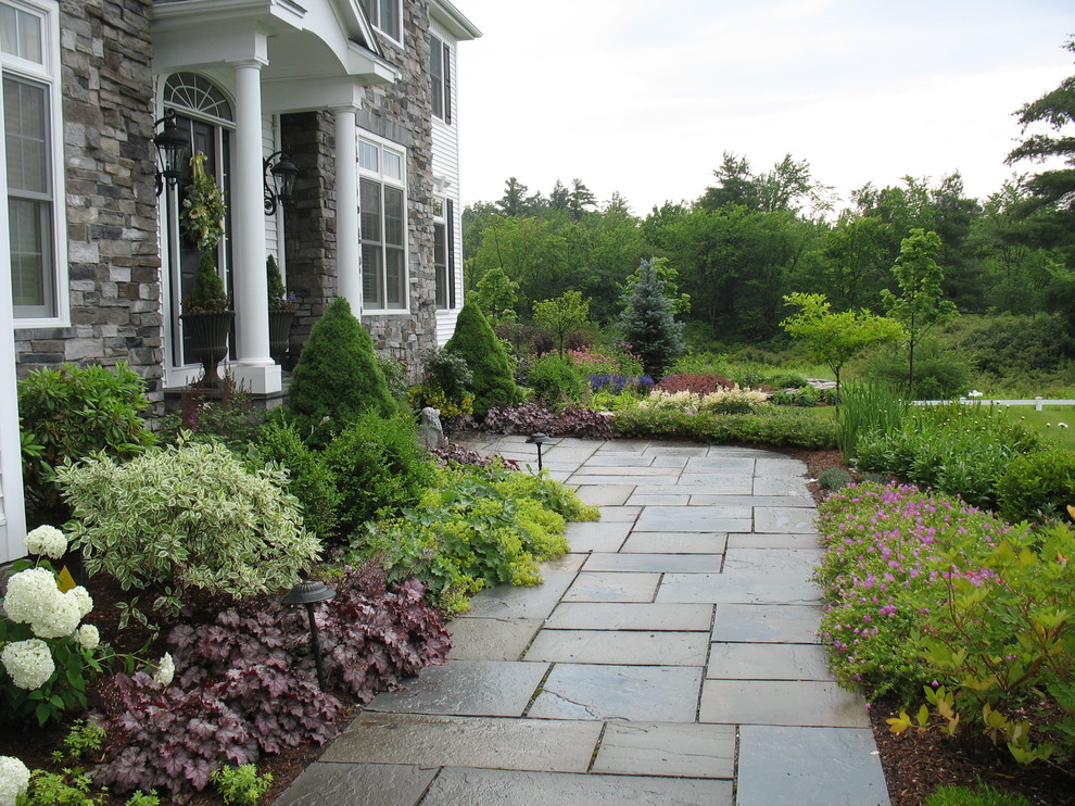 Photo of a traditional front yard full sun garden in Burlington with a garden path and natural stone pavers.