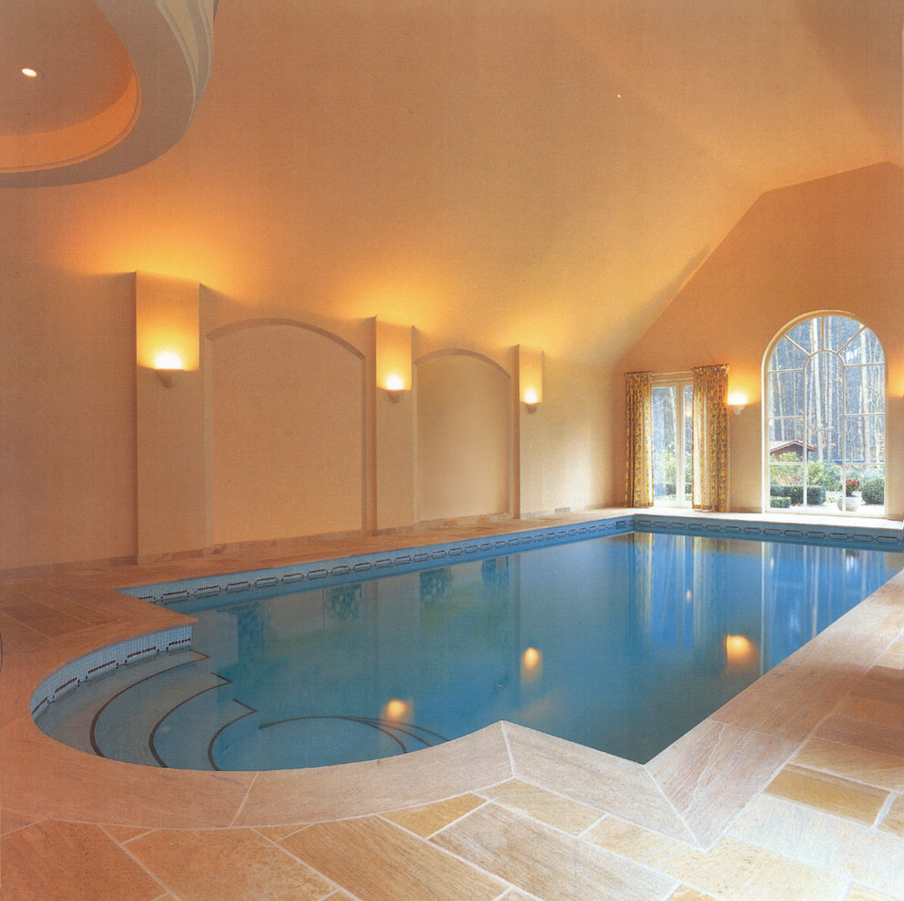 This is an example of an expansive contemporary indoor custom-shaped pool in Hamburg with natural stone pavers.