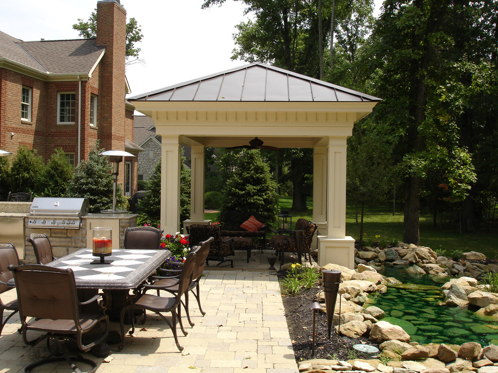 Ispirazione per un patio o portico di medie dimensioni e dietro casa con fontane, pavimentazioni in pietra naturale e una pergola