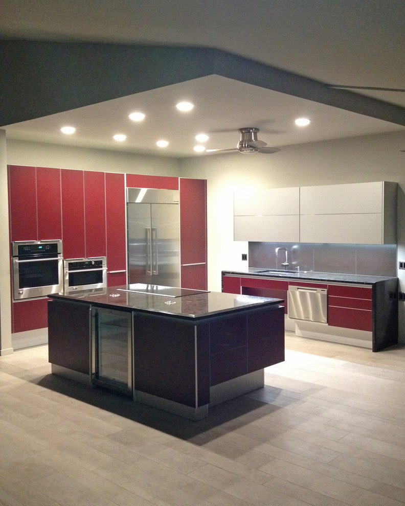 This is an example of a mid-sized contemporary eat-in kitchen in Hawaii with an undermount sink, flat-panel cabinets, red cabinets, granite benchtops, metallic splashback, porcelain splashback, stainless steel appliances and porcelain floors.