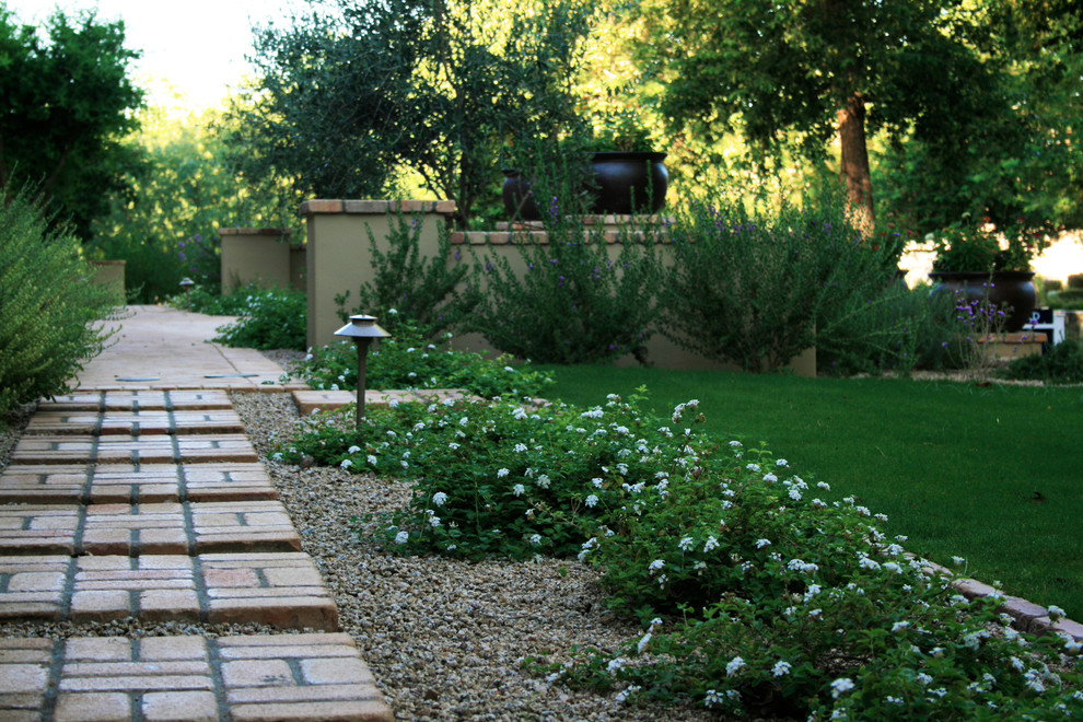 Large traditional backyard partial sun formal garden in Phoenix with a garden path and brick pavers.