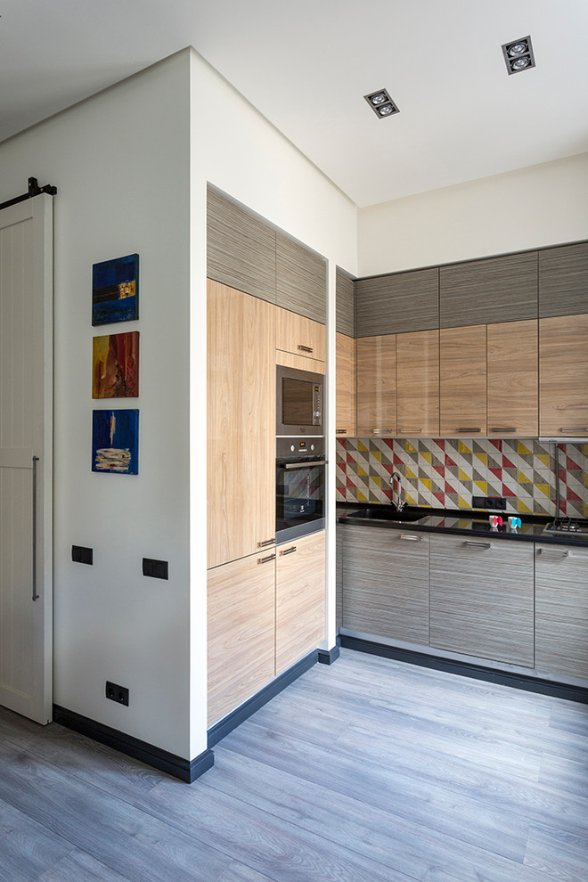This is an example of a small contemporary l-shaped open plan kitchen in Moscow with an integrated sink, flat-panel cabinets, quartz benchtops, multi-coloured splashback, terra-cotta splashback, stainless steel appliances, laminate floors and no island.