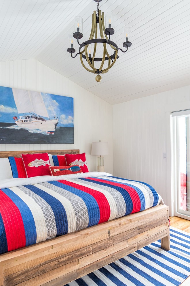 Photo of a mid-sized beach style bedroom in Toronto with white walls and medium hardwood floors.