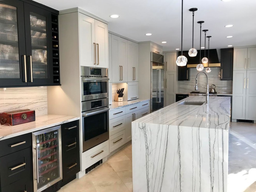 Design ideas for a large transitional l-shaped eat-in kitchen in Denver with an undermount sink, shaker cabinets, black cabinets, marble benchtops, white splashback, marble splashback, black appliances, limestone floors, with island, beige floor and white benchtop.