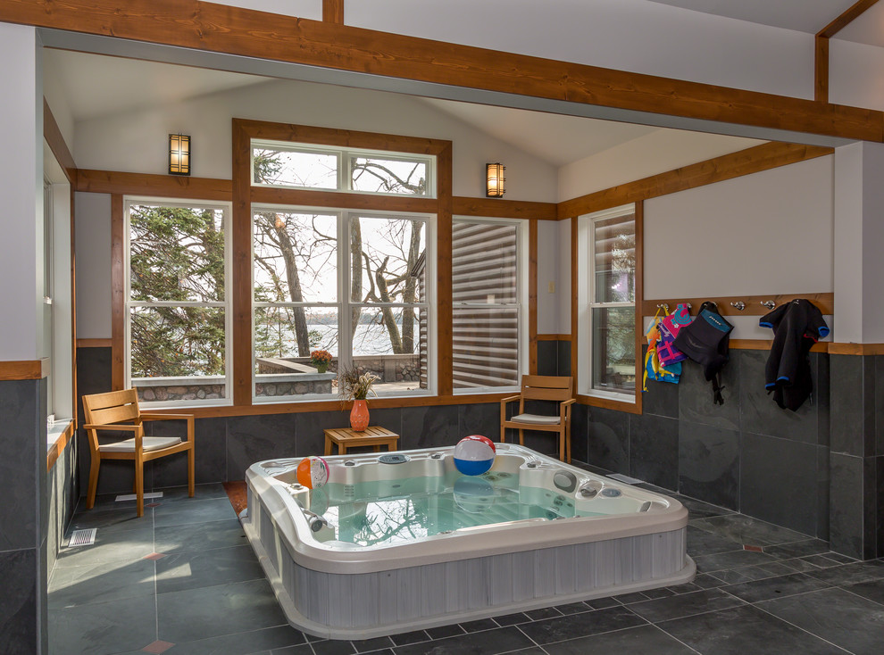 Inspiration for a large country indoor rectangular pool in Minneapolis with a hot tub and tile.