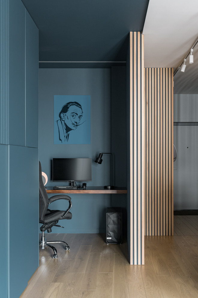 Immagine di un piccolo ufficio contemporaneo con pareti blu, pavimento in legno massello medio, scrivania incassata e pavimento beige