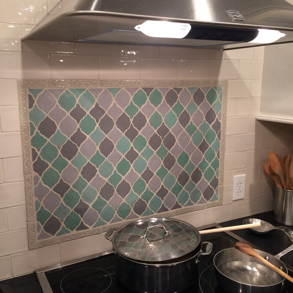 Kitchen - mid-sized transitional kitchen idea with subway tile backsplash, white backsplash, an island and black countertops