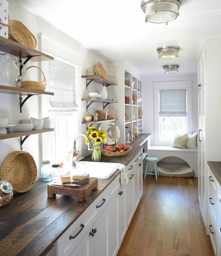 Inspiration for a beach style kitchen pantry in Charleston with a drop-in sink, recessed-panel cabinets, white cabinets, wood benchtops, dark hardwood floors, no island and brown floor.