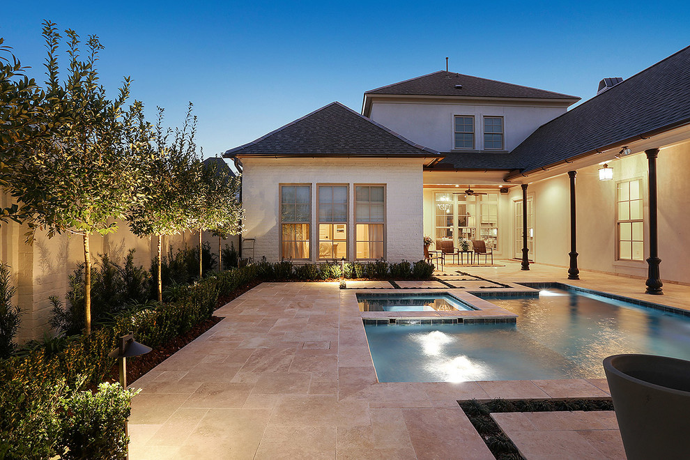 Small traditional courtyard custom-shaped pool in New Orleans with a hot tub and natural stone pavers.