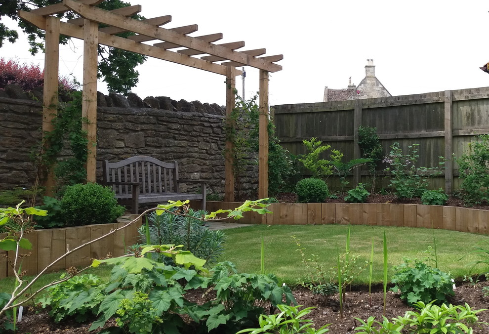 Ispirazione per un giardino minimalista esposto a mezz'ombra di medie dimensioni in estate con un pendio, una collina o una riva e recinzione in legno