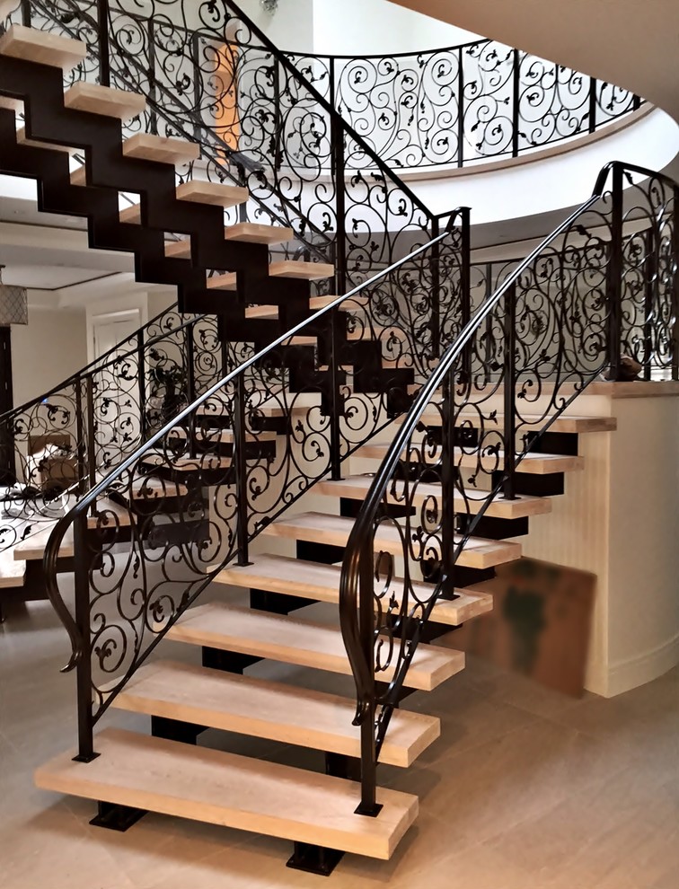 This is an example of a large traditional tile u-shaped staircase in Vancouver with open risers and metal railing.