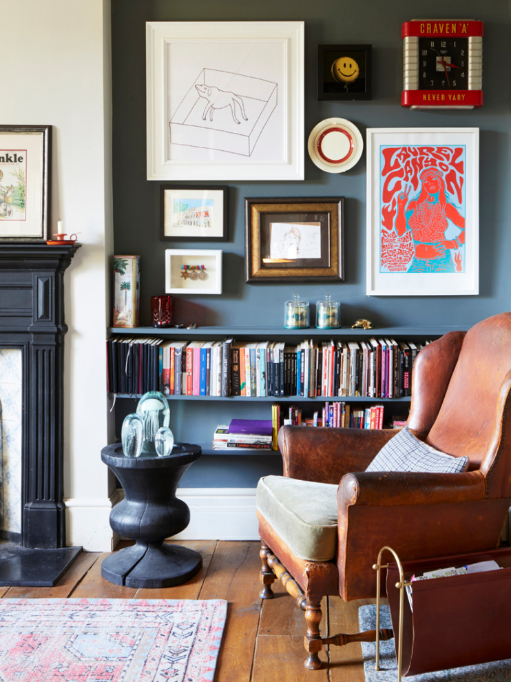 Photo of a mid-sized eclectic living room in London with medium hardwood floors, a standard fireplace and a metal fireplace surround.