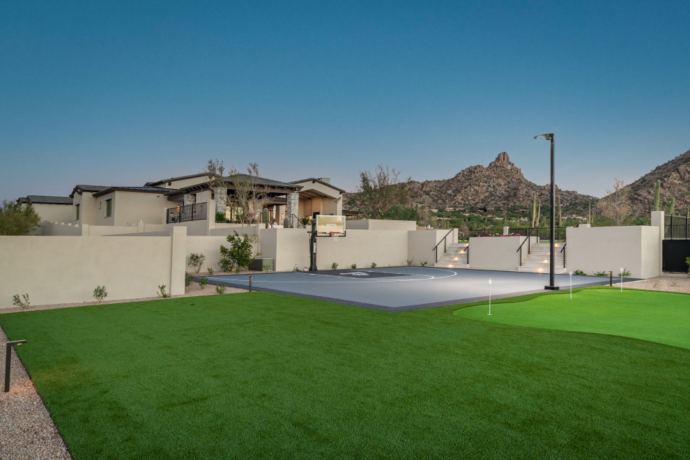 Großer Klassischer Garten im Sommer, hinter dem Haus mit Sportplatz, Feuerstelle, direkter Sonneneinstrahlung, Betonboden und Metallzaun in Phoenix