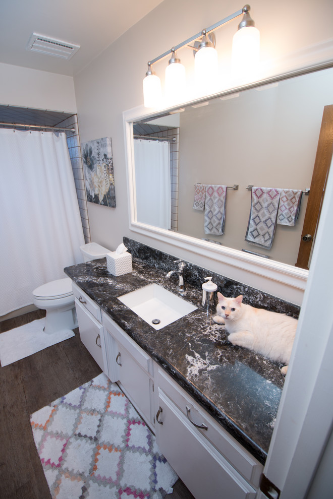 Photo of a small transitional bathroom in Other with white cabinets, an undermount sink and engineered quartz benchtops.