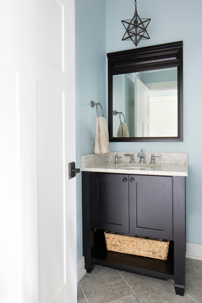 Small arts and crafts powder room in Milwaukee with furniture-like cabinets, brown cabinets, blue walls, ceramic floors, a drop-in sink, engineered quartz benchtops, beige floor and beige benchtops.