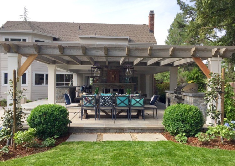 This is an example of a large country backyard patio in San Francisco with tile and a pergola.