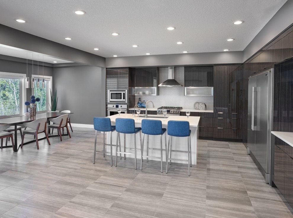 Design ideas for a mid-sized contemporary l-shaped kitchen pantry in Edmonton with an undermount sink, louvered cabinets, quartz benchtops, white splashback, porcelain splashback, stainless steel appliances, porcelain floors, multiple islands, grey floor and white benchtop.