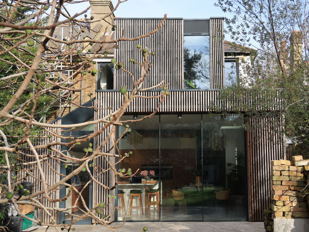 Immagine della facciata di una casa grigia contemporanea a due piani con rivestimento in legno