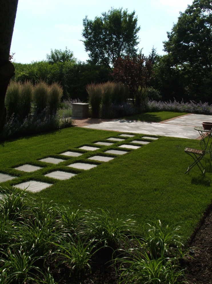 Contemporary backyard garden in Chicago with natural stone pavers.