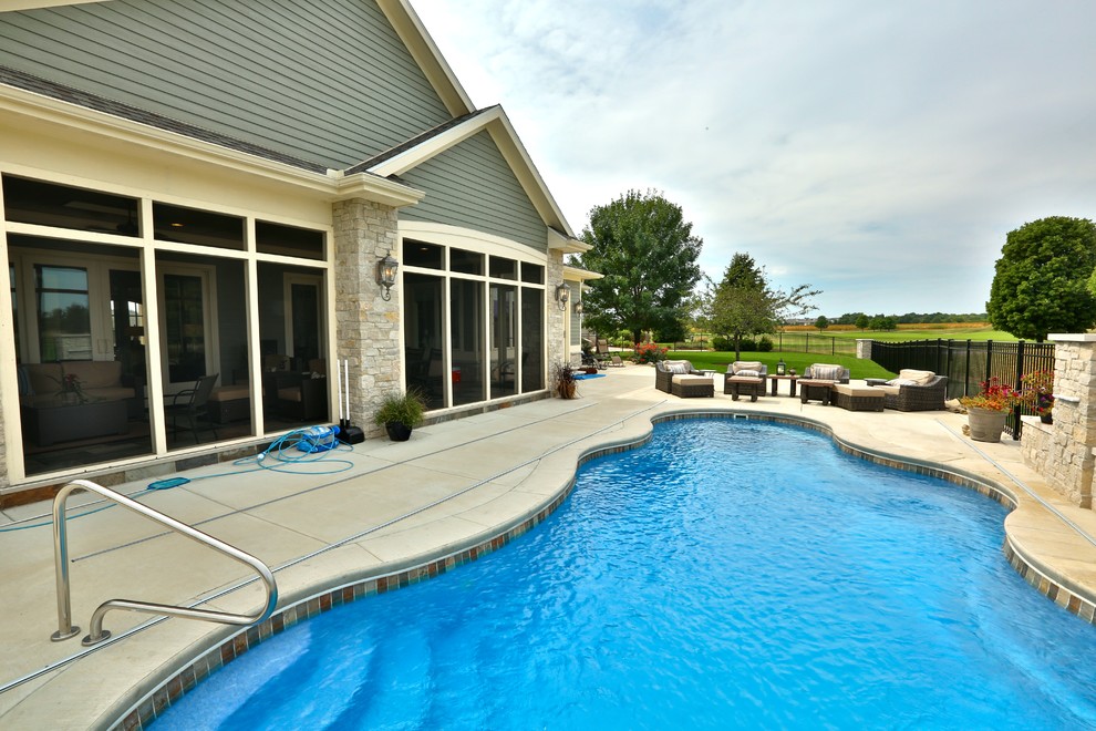 Mid-sized traditional backyard custom-shaped lap pool in Chicago with concrete slab.