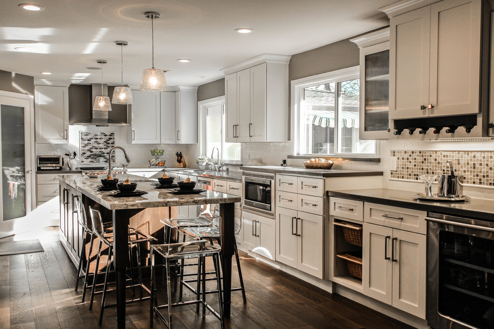 Design ideas for a large traditional u-shaped open plan kitchen in San Francisco with an undermount sink, shaker cabinets, white cabinets, granite benchtops, beige splashback, mosaic tile splashback, stainless steel appliances, medium hardwood floors and with island.